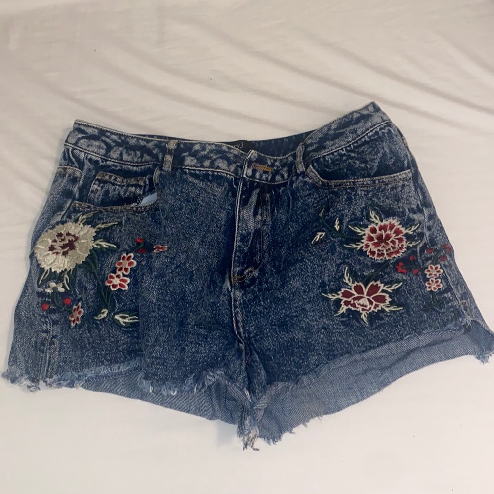 Flower Embroidered denim shorts with side slits.